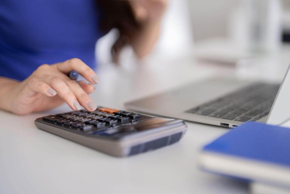 Savvy woman calculating finances on laptop