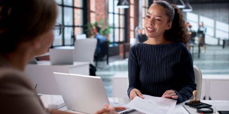 a woman sitting at a table with a laptop computer