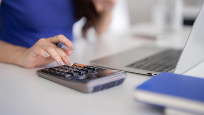 Savvy woman calculating finances on laptop
