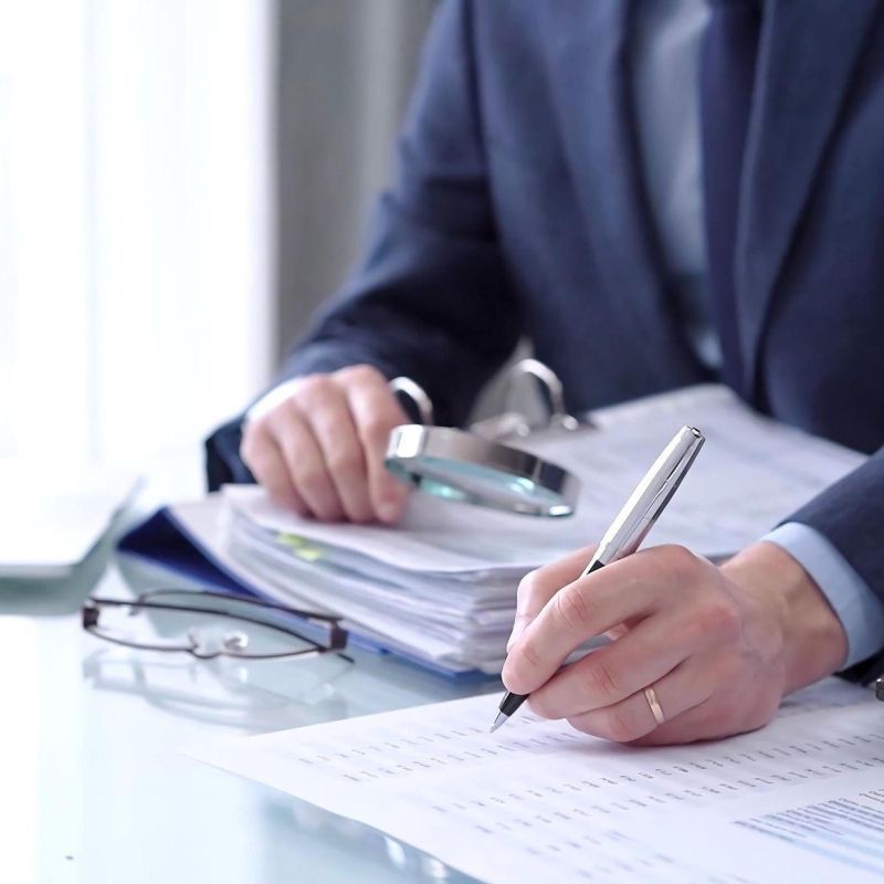 Business professional analyzing financial documents with a laptop and calculator on the desk.