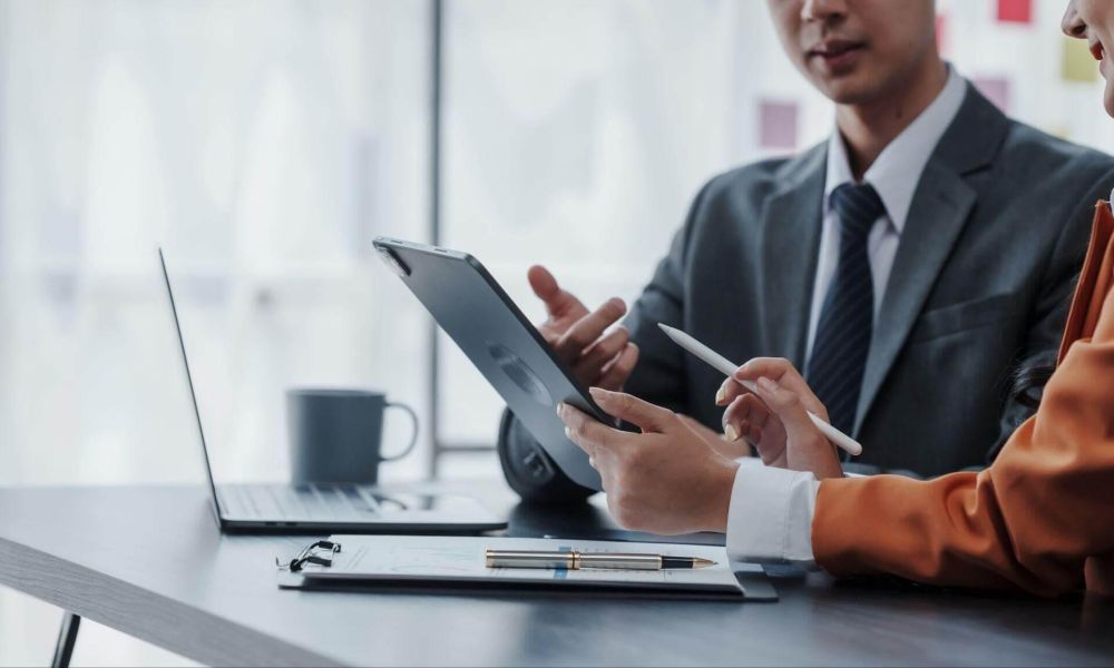 Two people working on a laptop at a table