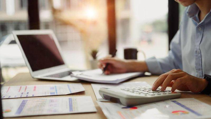 a man sitting at a desk using a calculator