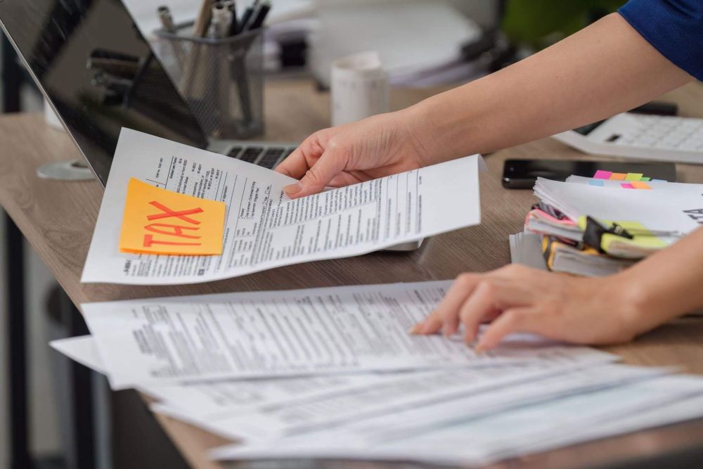 a person holding a piece of paper with a yellow sticker on it