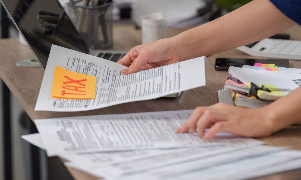 a person holding a piece of paper with a yellow sticker on it