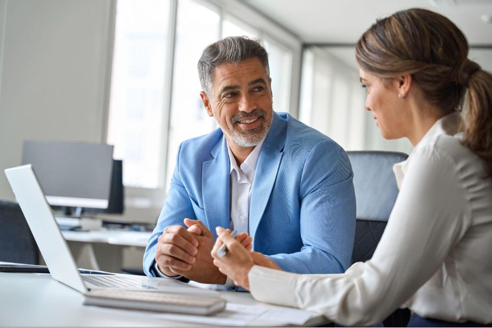 Man and woman having a professional discussion in a modern office setting.