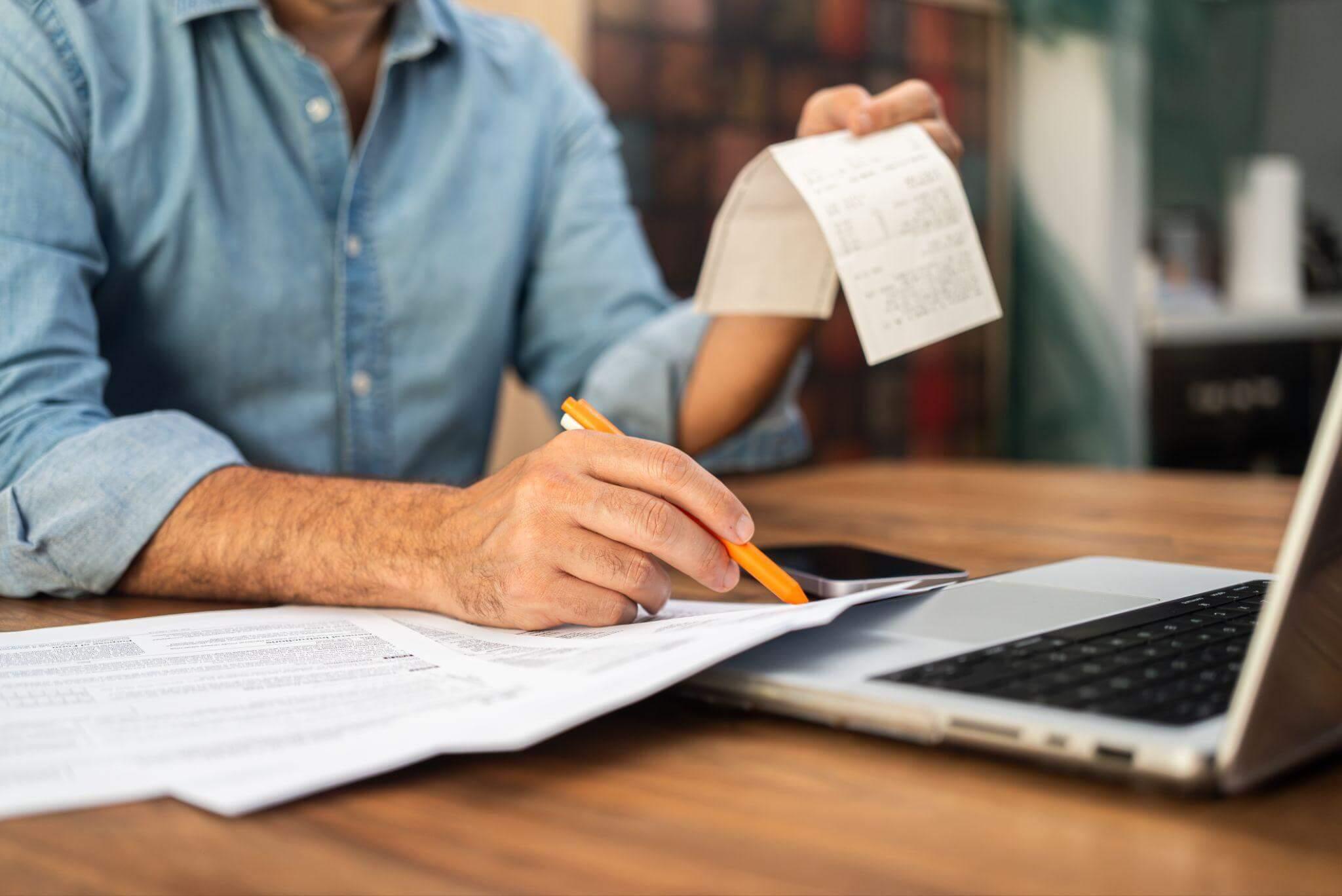 a man sitting at a desk with a laptop and a notepad