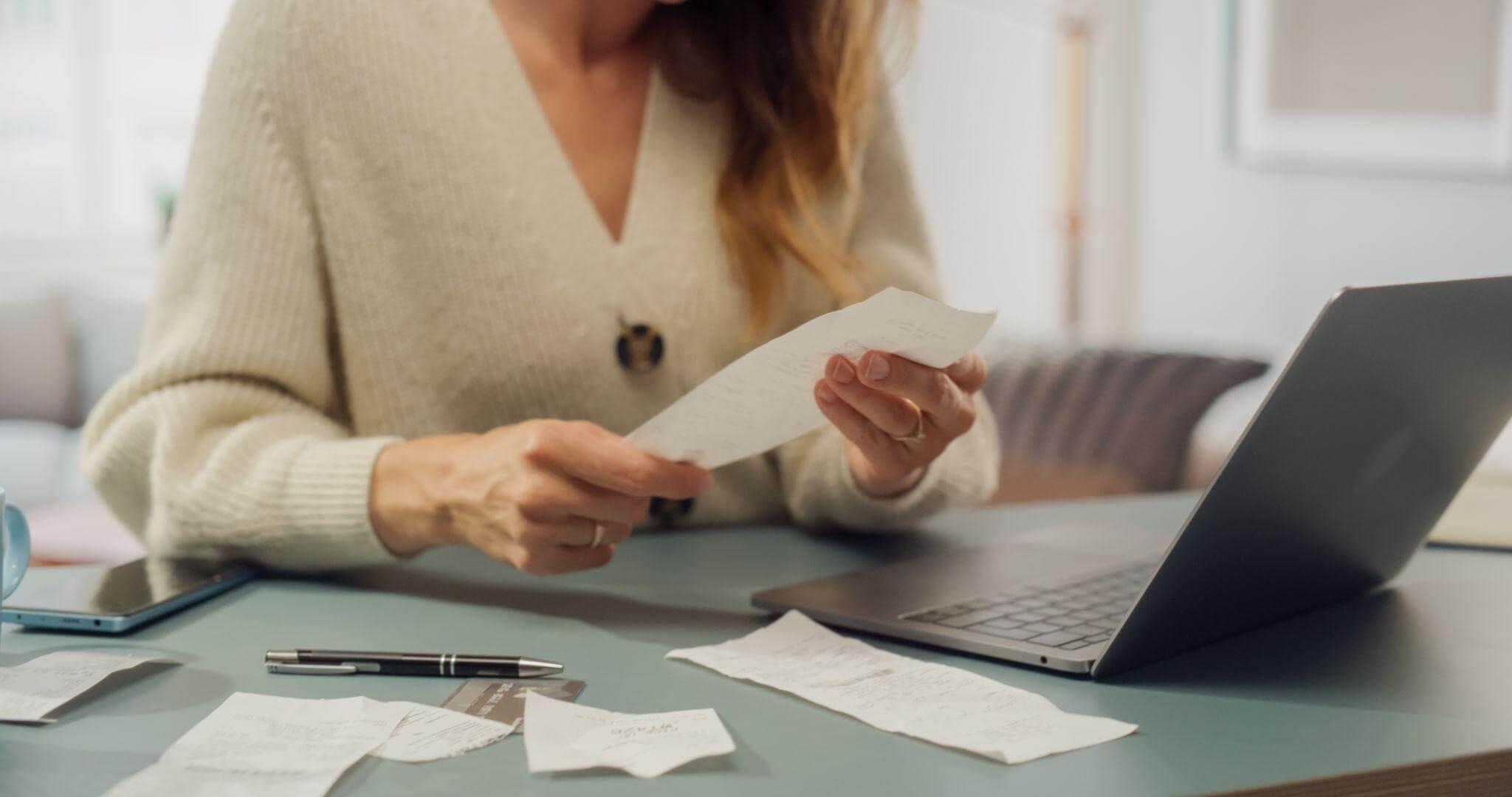 Woman working on a laptop with documents