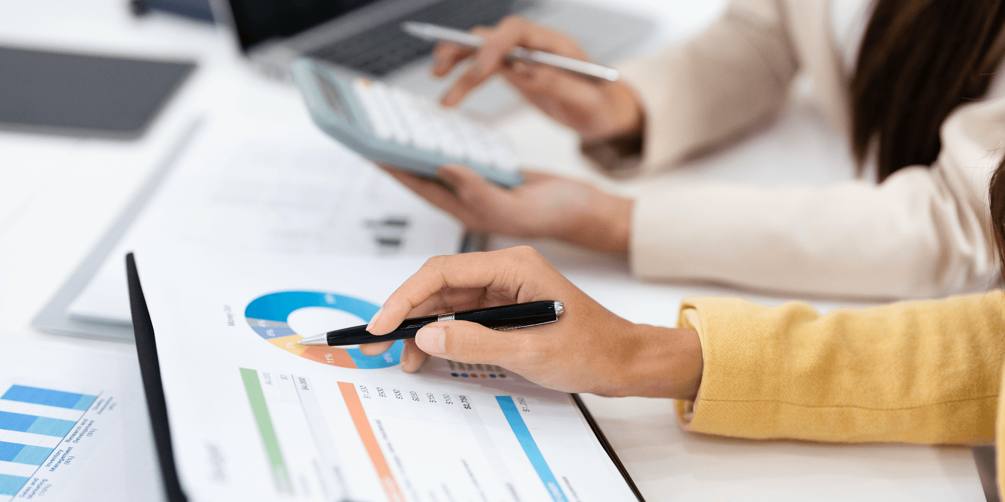 a woman is using a calculator on a desk